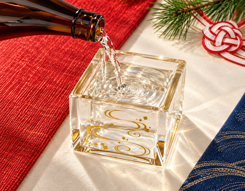 Pouring sake into the clear masu cup