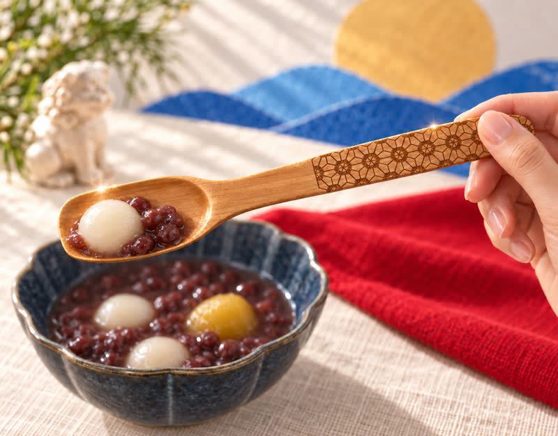 A wooden spoon lifting shiratama from zenzai